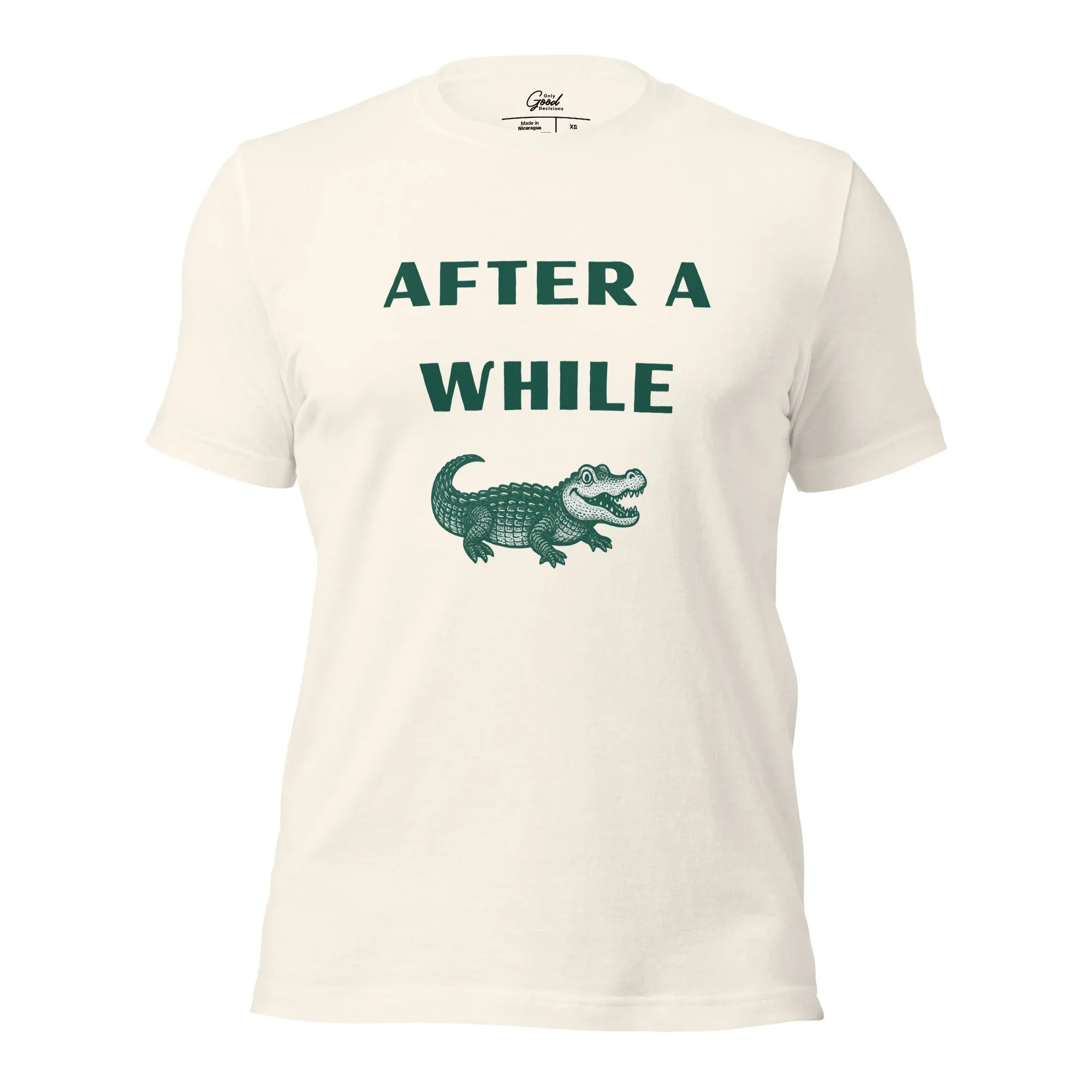 Vintage White After A While Crocodile classic idiom t-shirt featuring the text "AFTER A WHILE" in green above an illustration of a crocodile.